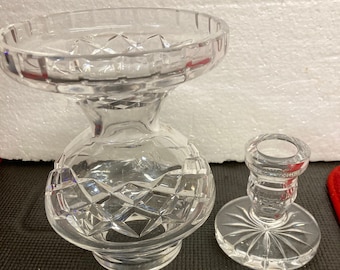 May include: A set of two clear glass crystal vases with a cut glass design. The larger vase is taller and has a wider base. The smaller vase is shorter and has a narrower base.