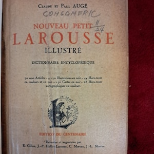Puede incluir: Portada de un diccionario ilustrado vintage titulado "Nouveau Petit Larousse Illustré" con una ilustración roja y negra de una mujer sembrando semillas. El libro fue publicado en 1953 por Librairie Larousse en París.