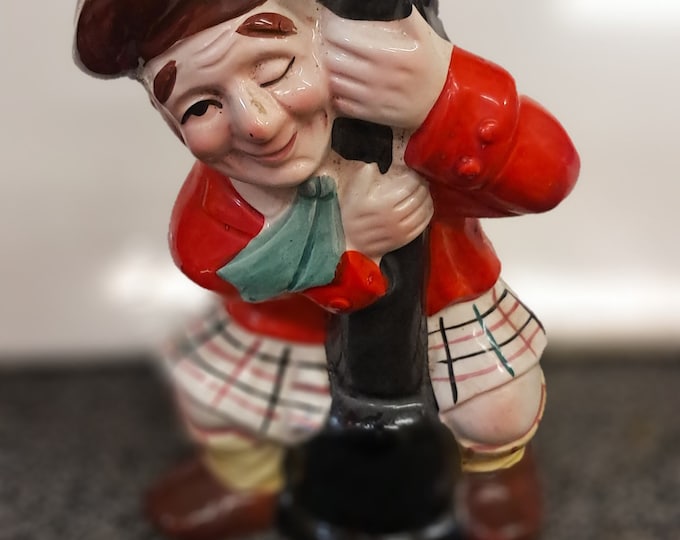 Vintage Figurine of Scotsman Holding on  to  Street Light Pole.