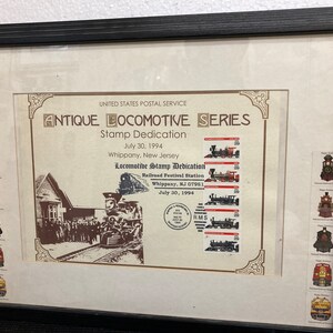 May include: A framed print commemorating the Antique Locomotive Series stamp dedication in Whippany, New Jersey on July 30, 1994. The print features images of the stamps, a photograph of the event, and the text "United States Postal Service Antique Locomotive Series Stamp Dedication".