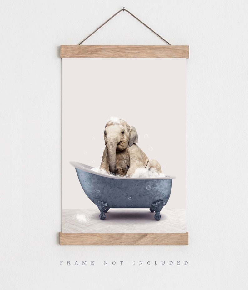 Peut inclure: Un b&eacute;b&eacute; &eacute;l&eacute;phant prend un bain dans une baignoire bleue avec des bulles blanches. L'&eacute;l&eacute;phant est assis dans la baignoire, sa trompe lev&eacute;e et ses oreilles dress&eacute;es. L'arri&egrave;re-plan est de couleur rose p&acirc;le.
