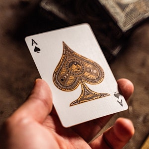 The ace of spade of wayfarers playing cards held in one hand