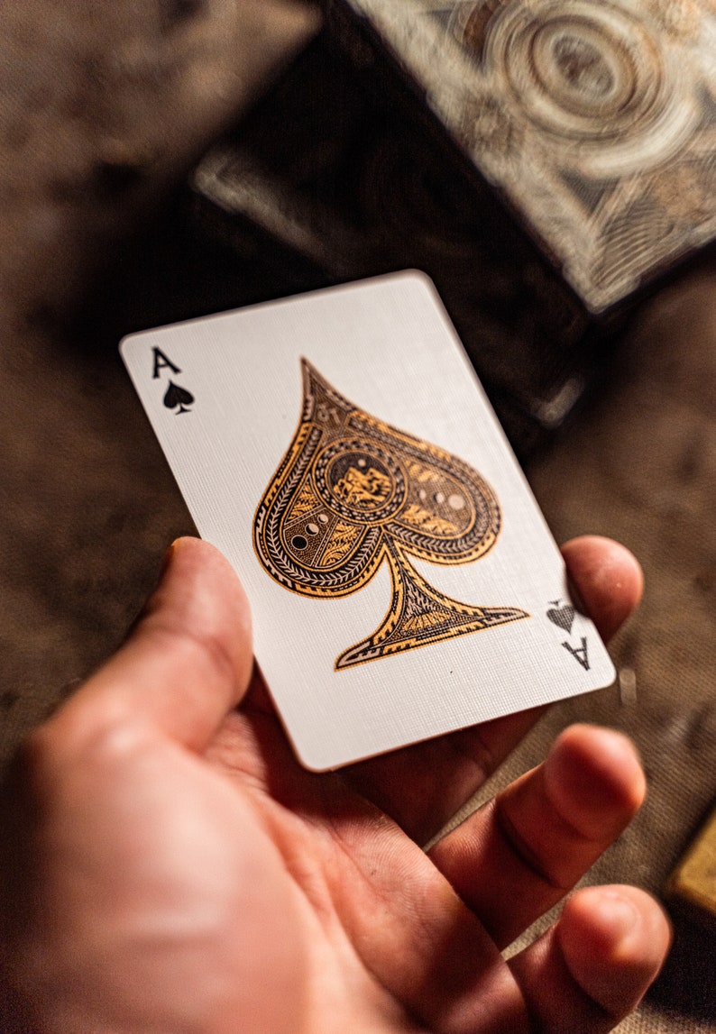 The ace of spade of wayfarers playing cards held in one hand