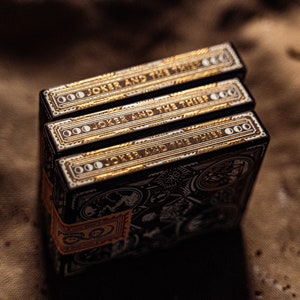 Three decks of wayfarers playing cards displaying the sides of the box