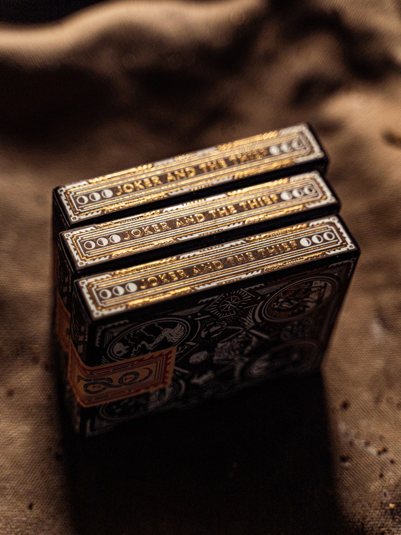 Three decks of wayfarers playing cards displaying the sides of the box