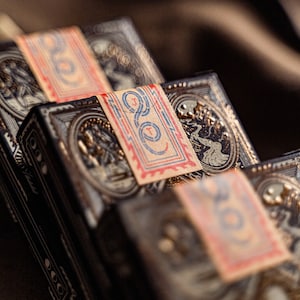 Close up details of three decks of wayfarers playing cards displaying the packaging seal