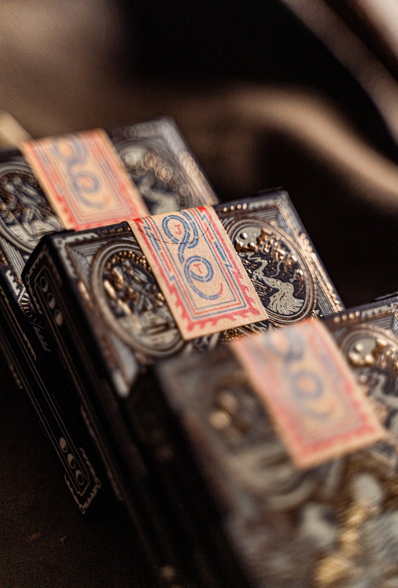 Close up details of three decks of wayfarers playing cards displaying the packaging seal