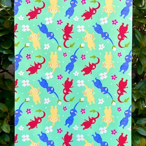 May include: A green background with a repeating pattern of yellow, blue, and red creatures with long tails. The creatures are surrounded by white and pink flowers.