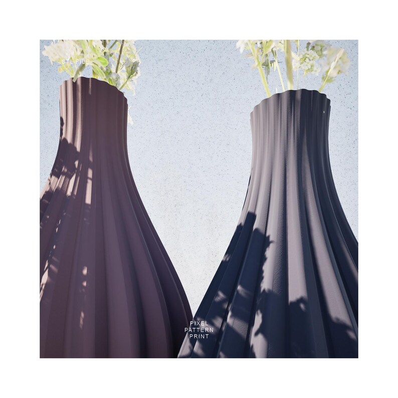 May include: Two ceramic vases with a fluted design. The vase on the left is a dark purple color and the vase on the right is a dark gray color. Both vases have white flowers in them.