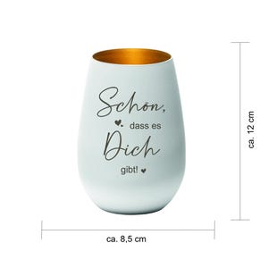 May include: A white, egg-shaped candle holder with a gold interior. The candle holder is approximately 4.7 inches tall and 3.3 inches wide. The text "Sch&ouml;n, dass es Dich gibt!" is written on the front.