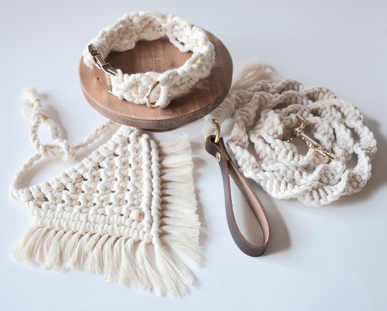 May include: A set of three handmade dog collars and leashes made from macrame rope. The collars and leashes are cream colored and have a fringe detail. The set includes a collar, a leash, and a separate lead.