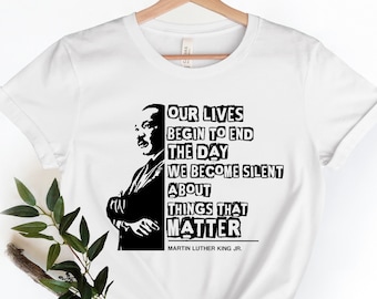 May include: White t-shirt with a black and white image of Martin Luther King Jr. and a quote that reads "Our lives begin to end the day we become silent about things that matter. Martin Luther King Jr."