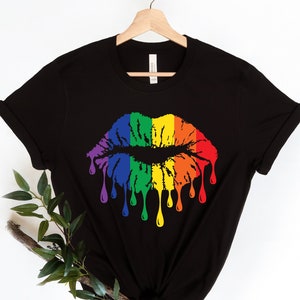 May include: Black t-shirt with a rainbow dripping lips graphic.