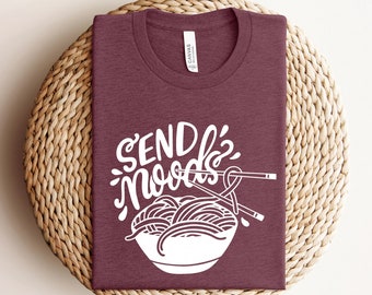 May include: A maroon t-shirt with the text "Send Noodles" in white lettering. The text is stylized with a noodle bowl and chopsticks.