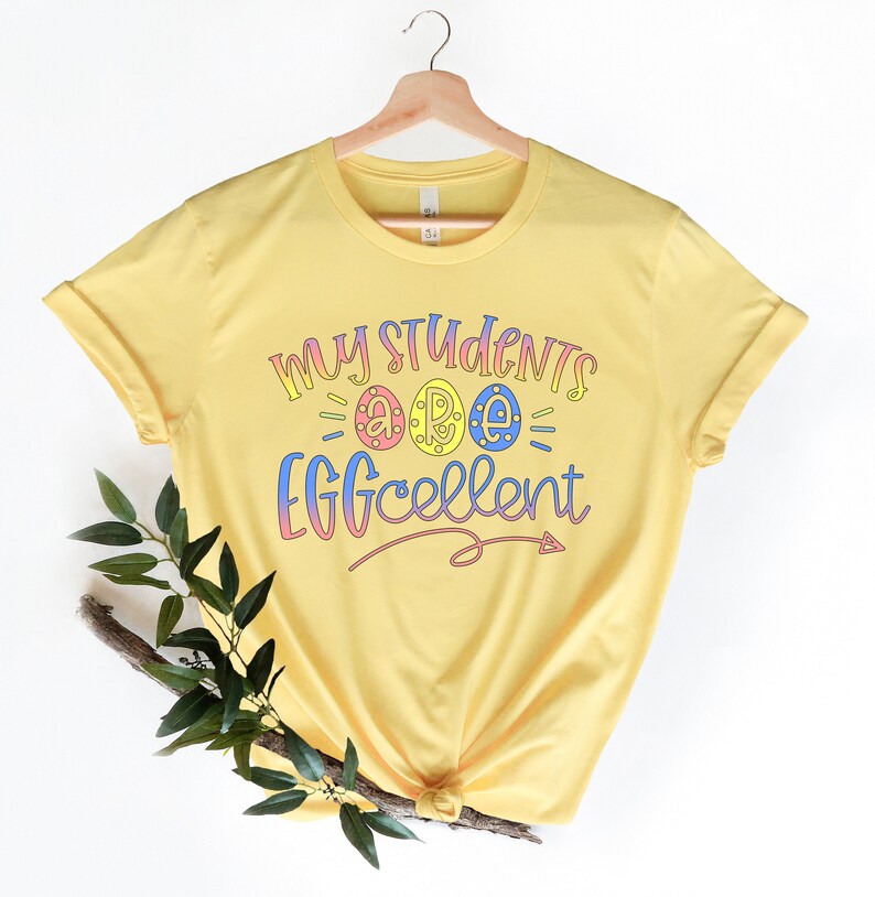 May include: Yellow t-shirt with the text "My Students are Eggcellent" in rainbow colors. The text includes three eggs with the letters "a", "r", and "e" inside.