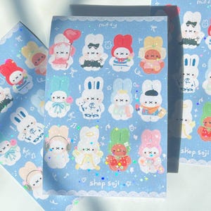 May include: Sheets of stickers featuring cartoon bunnies in various outfits and poses. The stickers are on a light blue background with the word "miffy" at the top and "shop soji" at the bottom. The stickers have a glittery effect.