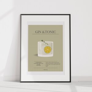 May include: A framed print featuring a Gin & Tonic cocktail illustration. The artwork includes a detailed depiction of the drink in a glass, a lime wedge, and sprigs of herbs. The text "GIN & TONIC" is displayed at the top.