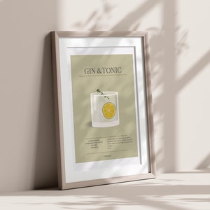 May include: Framed art print featuring a Gin & Tonic cocktail illustration. The artwork displays a glass with a lemon slice and herbs, set against a neutral background. The print includes the drink's name and ingredients.