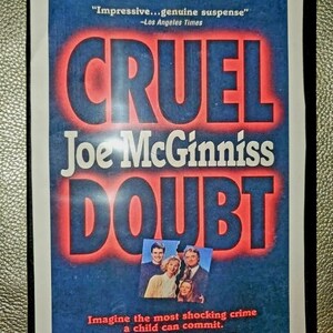 May include: DVD cover for the miniseries "Cruel Doubt" based on the #1 New York Times bestseller by Joe McGinniss. The cover features a red and blue color scheme with the title "Cruel Doubt" in large, bold letters. The text "Imagine the most shocking crime a child can commit. Imagine a mother suspects." is also featured on the cover.