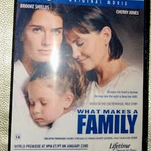 Puede incluir: Una carátula de DVD para la película original de Lifetime "What Makes a Family" protagonizada por Brooke Shields y Cherry Jones. La carátula presenta una foto de las tres actrices, con el título en letras azules grandes.
