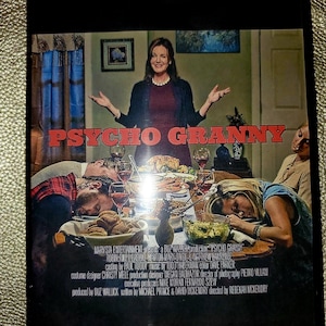 Op de afbeelding: DVD-hoes voor de film "Psycho Granny". De hoes toont een vrouw in een bordeauxrode jurk met een bezorgde uitdrukking, die voor een eettafel staat met andere mensen. De tekst "Psycho Granny" staat in rode letters op een zwarte achtergrond.
