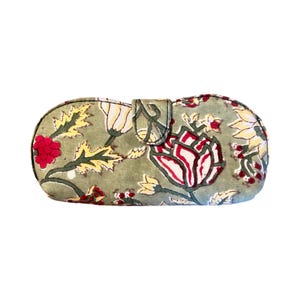 May include: A green fabric eyeglass case with a floral print featuring red, white and yellow flowers.