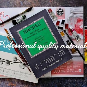 May include: An assortment of watercolor art supplies, including watercolor paper, paint tubes, paint brushes, and a palette of watercolor paints. The text "Professional quality materials" is visible.