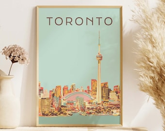 May include: A framed print with a vintage style illustration of the Toronto skyline, featuring the CN Tower and other buildings. The print has a light blue background and the word "TORONTO" in brown text at the top.