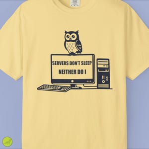 Puede incluir: Camiseta amarillo claro con un diseño negro de un búho sobre un monitor, teclado y torre de ordenador. El texto en el monitor dice: "SERVERS DON'T SLEEP NEITHER DO I."