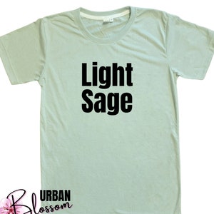 May include: A light sage green t-shirt with the text "Light Sage" printed in black.