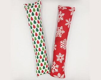 May include: Two long, rectangular catnip toys. One is red with white snowflakes and the other is white with red and green Christmas trees.