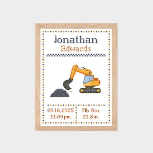 May include: A framed cross-stitch birth announcement featuring a yellow excavator and a pile of dirt. The text reads Jonathan Edwards, 03.16.2025, 11:09pm, 7lb.8oz., and 21.8in. The design is bordered by a blue and orange dotted pattern.