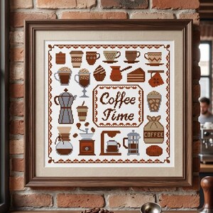 May include: A framed cross-stitch sampler featuring various coffee-themed icons and the text "Coffee Time" in brown thread on a white background. The design includes illustrations of coffee mugs, a moka pot, a French press, and coffee beans.