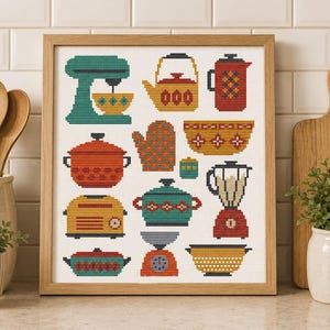 May include: A framed cross-stitch embroidery featuring a collection of kitchen items including a teal stand mixer, a yellow kettle, a red coffee press, a red pot, an oven mitt, a yellow bowl, a yellow toaster, a teal pot, a blender, and a scale.