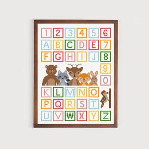 May include: A colourful alphabet and number chart with a brown bear, raccoon, deer, fox, and rabbit. The animals are arranged in a row below the chart. A woodpecker is perched on a branch to the right of the chart.