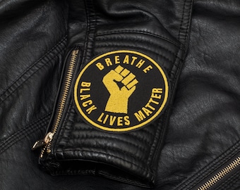 May include: Black leather jacket with a yellow embroidered patch that says "Breathe Black Lives Matter" and a raised fist.