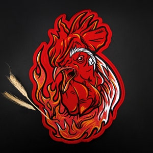 May include: Red embroidered patch of a rooster with flames behind it. The rooster is facing forward with its beak open and its eyes wide open. The flames are orange and yellow.