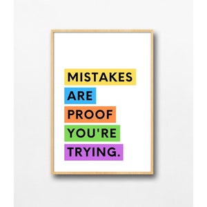 May include: A motivational quote in a colorful typography design. The quote reads "Mistakes are proof you're trying." The quote is printed on a white background and framed with a light wood frame.