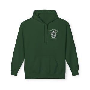 May include: A dark green hoodie with a front pocket and a hood. The hoodie features a white graphic on the upper left chest that includes a skull, text that reads "HOUSE OF BLACK", and other decorative elements. The hoodie is made of a soft material.