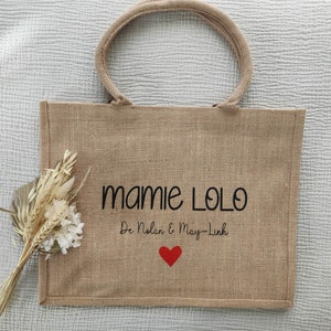 May include: A brown burlap tote bag with black embroidered text that reads "Mamie Lolo De Nolan & May-Linh" and a red heart.