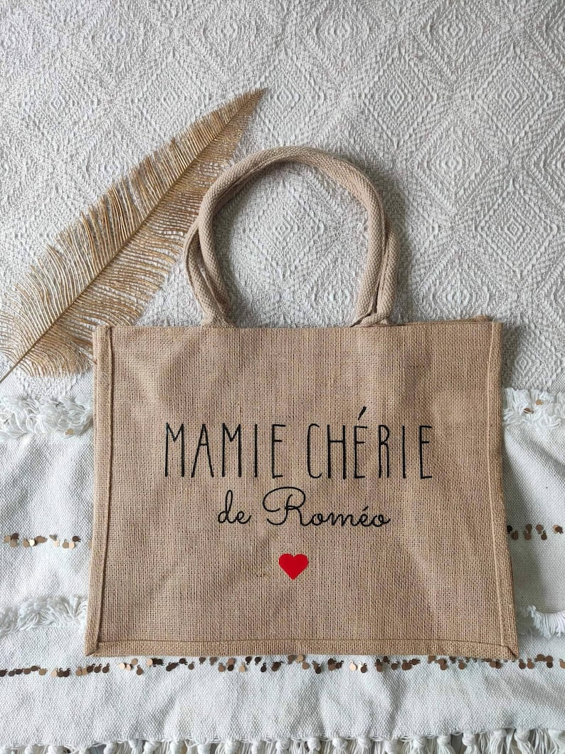 May include: A brown burlap tote bag with black text that reads "MAMMIE CH&Eacute;RIE de Rom&eacute;o" and a red heart.