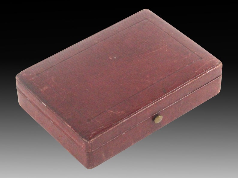 May include: A small, rectangular, burgundy leather box with a brass latch.