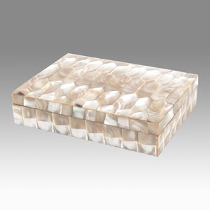 May include: Rectangular decorative box with a mother-of-pearl mosaic pattern. The box is a light cream color with a geometric design on the lid and sides. The box is a storage container.