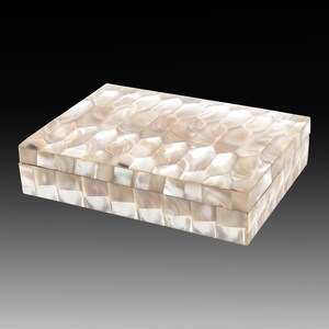 May include: Rectangular decorative box with a mother-of-pearl mosaic design. The box is white and cream-colored, with a geometric pattern on the lid and sides. The box is closed and sits on a gradient background.