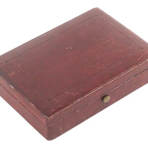 May include: A small, rectangular, burgundy leather box with a brass clasp.