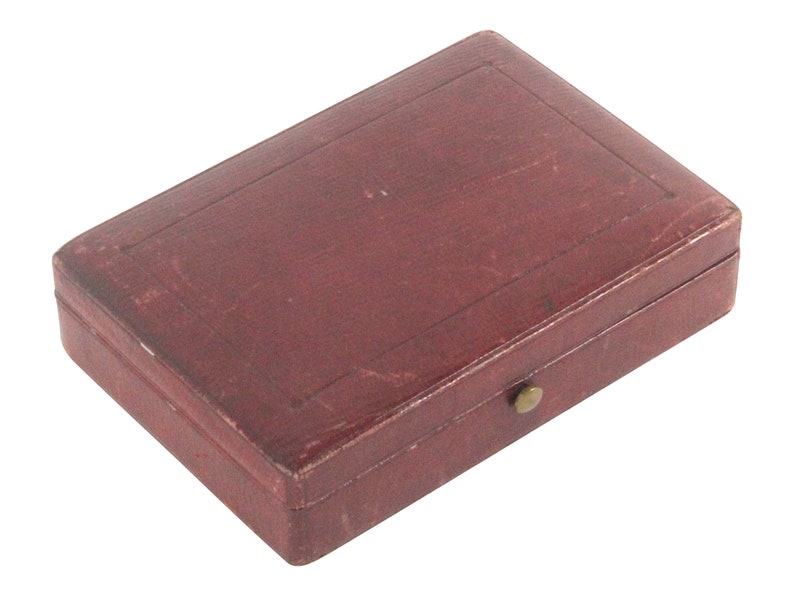 May include: A small, rectangular, burgundy leather box with a brass clasp.