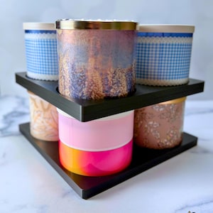May include: A black triangular candle storage system consisting of one base and one stacker, designed to hold multiple cylindrical candles. The unit features cutouts for candle placement. Text on the image reads 1 BASE + 1 STACKER.