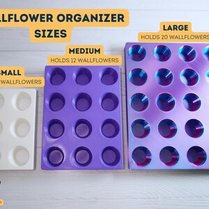 May include: Three wallflower organizers in different sizes: small, medium, and large. The small organizer is white and holds 6 wallflowers. The medium organizer is purple and holds 12 wallflowers. The large organizer is iridescent purple and holds 20 wallflowers.