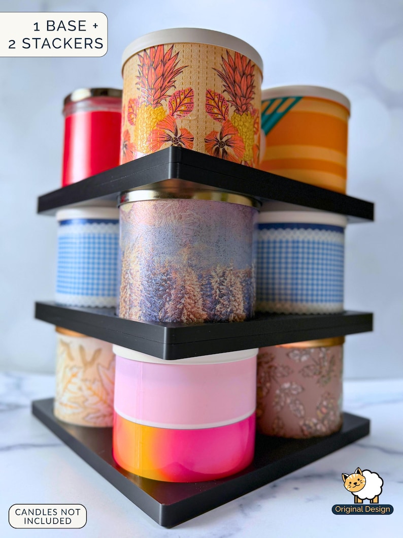 May include: A black three-tiered triangular display stand with one base and two stackers, holding nine cylindrical candles with various colourful patterns and designs. Text on the image reads 1 BASE + 2 STACKERS and CANDLES NOT INCLUDED.