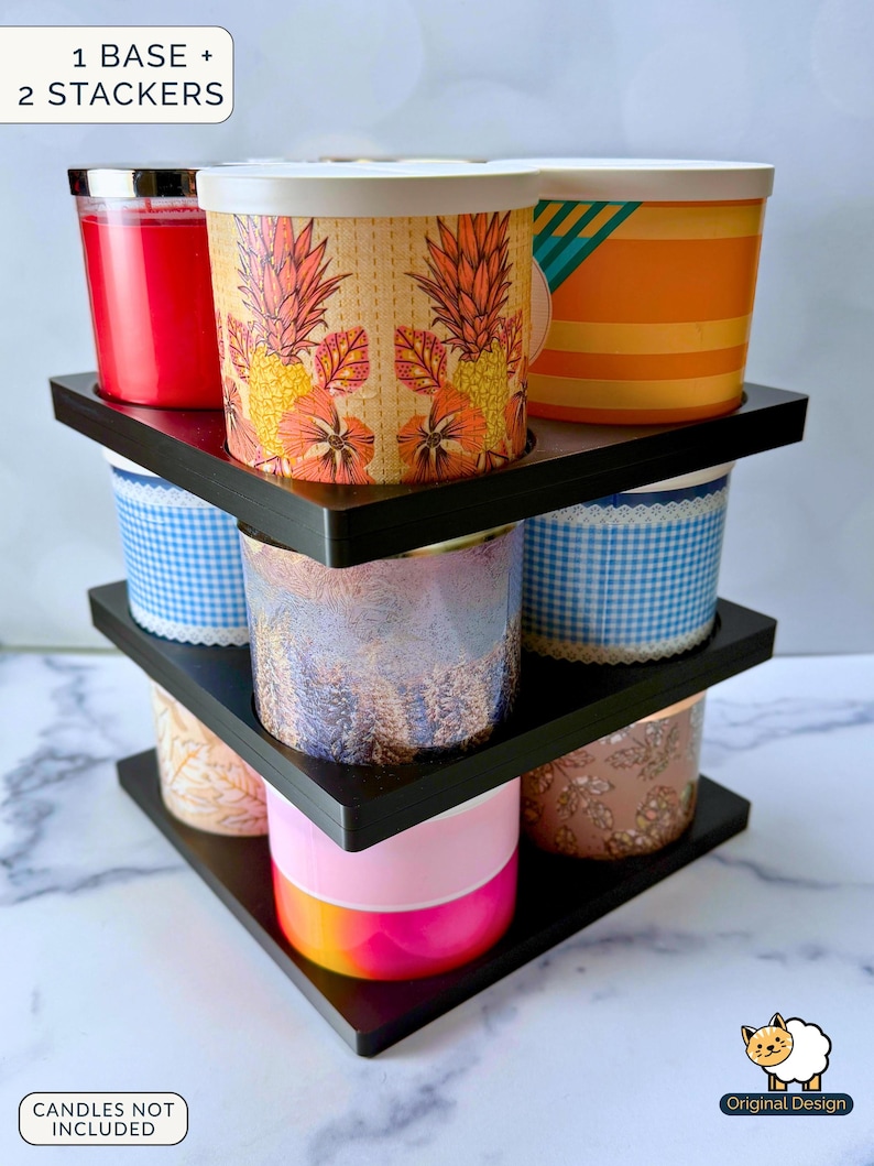 May include: A black tiered candle storage rack consisting of one base and two stackers, designed to hold multiple cylindrical candles. The structure features three levels with circular cutouts for candles, displaying various colourful candle jars.